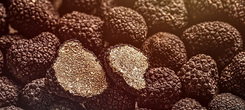 Black truffles with marbled interior featured in gourmet cuisine article.