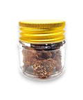 Brown dried spring truffle Tuber Borchii in glass jar with gold lid for gourmet cooking