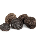 Pile of earthy fresh black Tuber Melanosporum B-grade black truffles for gourmet cooking