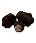 Fresh Winter Truffle Tuber Brumale with one cut open showing rich interior